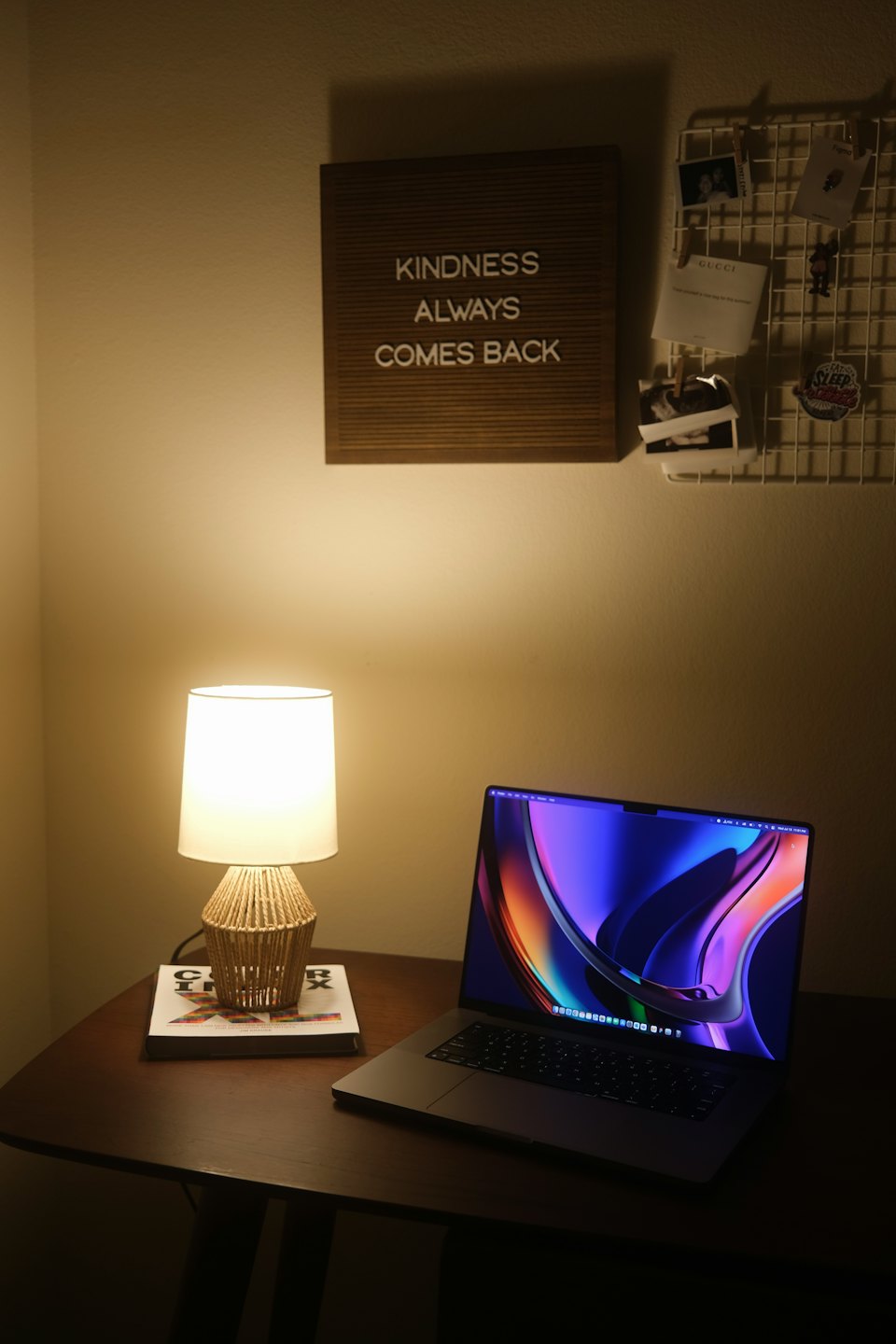 Laptop and letter board on a wooden desk in a home office.