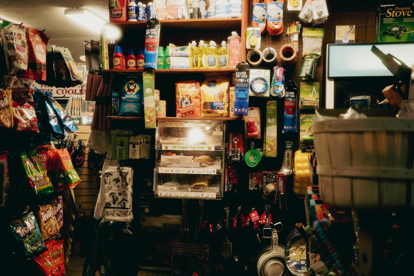 Wooden shelves filled with diverse goods in a rustic store.